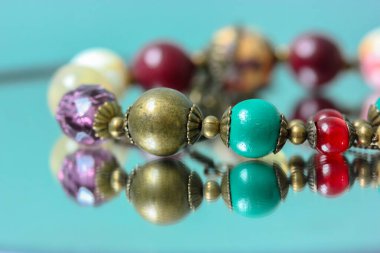 Renkli kolyeler aynaya yansıyor.