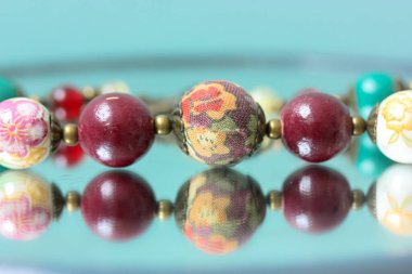 Renkli kolyeler aynaya yansıyor.