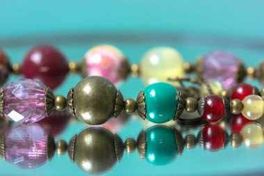 Renkli kolyeler aynaya yansıyor.