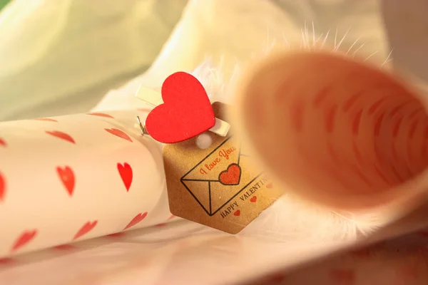 Brown envelope with a note of love confession for a loved one on Valentine\'s Day, the inscription I love you and a red heart with white feathers.