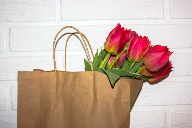 Kese kağıdındaki pembe lale buketi: Rodos Günü için bir hediye..