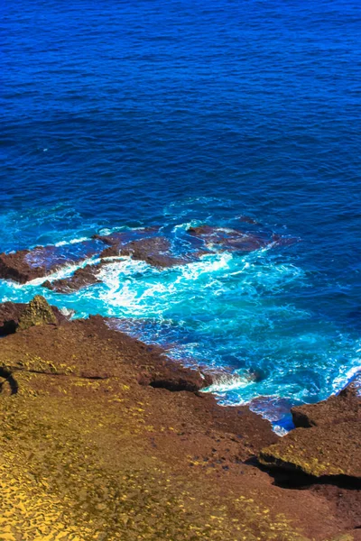 Yazın Atlantik Okyanusu: mavi dalgalar kayalıklara kırılarak beyaz köpük oluşturur — Stok fotoğraf