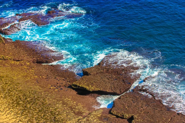 Ατλαντικός Ωκεανός το καλοκαίρι: μπλε κύματα σπάσει σε βράχια, σχηματίζοντας λευκό αφρό — Φωτογραφία Αρχείου