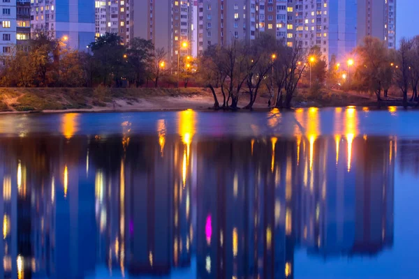 Silhuetter Flervåningshus Med Starkt Ljus Fönstren Reflekterar Över Den Blå — Stockfoto