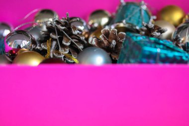 Noel ağacı oyuncakları ve pembe bir kutuda çam kozalakları, 2021-2022 yıllarında arka planda