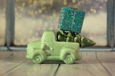 Noel ağacı olan bir oyuncak araba ve pencereye dayalı bir kutu hediye.