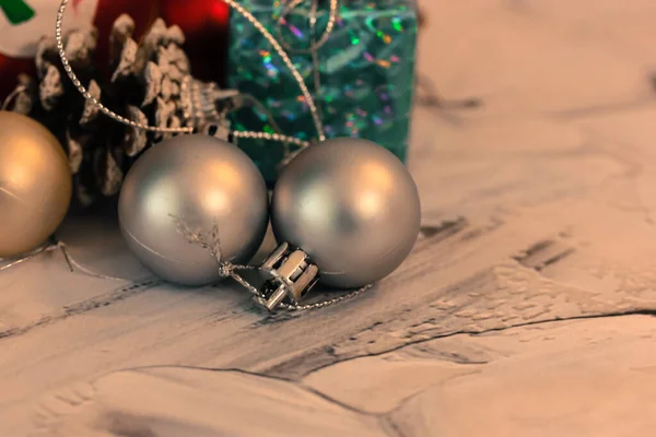 Altın ve gümüş toplar şeklinde Noel ağacı oyuncakları, çam kozalakları ve yakın plan hediye kutuları. Yeni yıl şenlik arkaplanı — Stok fotoğraf