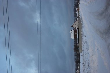 Ufuktaki özel eve erişim yolu, karlı kış ve mavi bulutlu gökyüzü