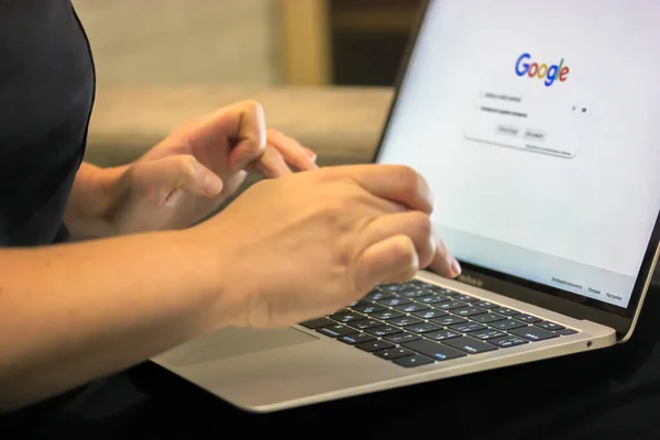 Κορίτσι που ψάχνει για πληροφορίες σχετικά με τη μηχανή αναζήτησης Google, πληκτρολογώντας στο πληκτρολόγιο laptop με τα δάχτυλά της — Φωτογραφία Αρχείου