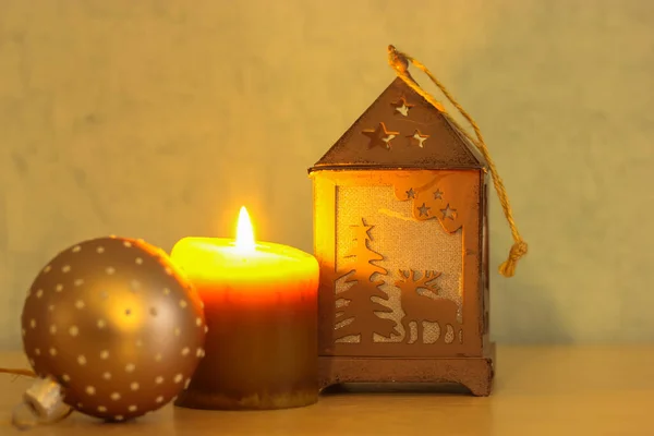 Decoração de Ano Novo: vela ardente, lanterna de rena decorativa, close-up brinquedo de árvore de Natal, fundo festivo quente — Fotografia de Stock