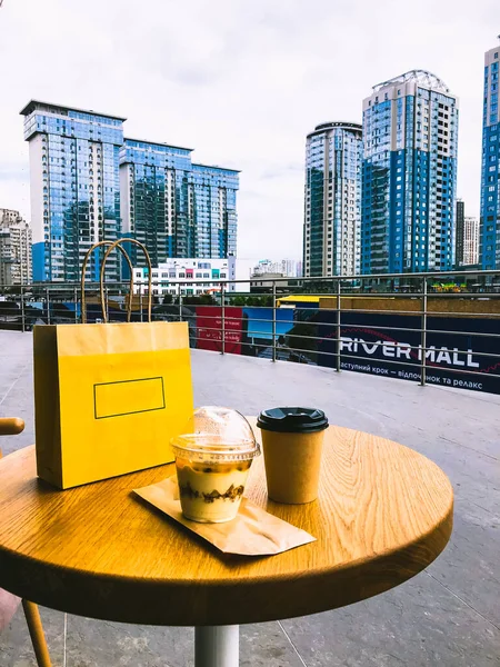 Terasta yuvarlak masa, alışveriş sonrası tatlı ve kahve. Şehrin finans merkezindeki yüksek binaların manzarası. — Stok fotoğraf