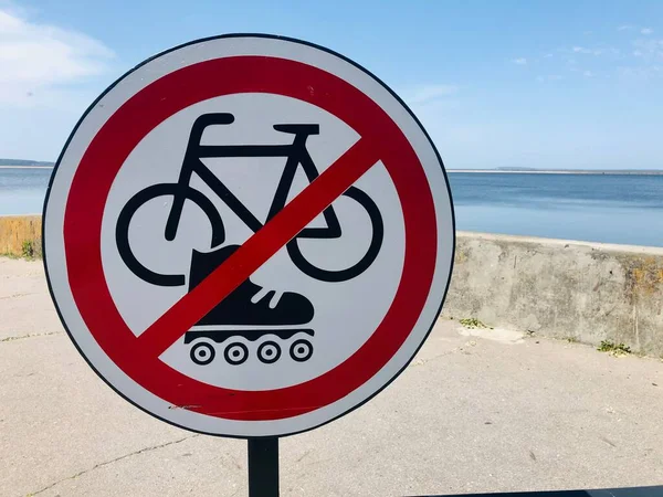 Round white and red sign prohibiting cycling and rollerblading on the waterfront