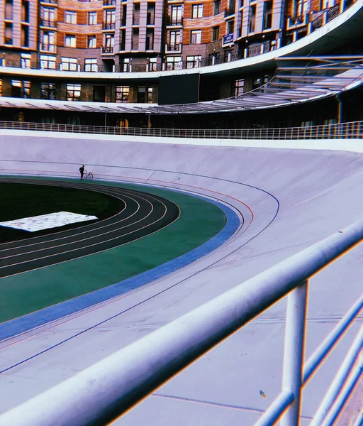 Pista de ciclismo y ciclista en un estadio vacío en el patio de edificios de apartamentos en la gran ciudad. Kiev, Ucrania — Foto de Stock