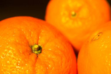 Olgunlaşmış portakallar siyah arkaplanda, kışın C vitamini