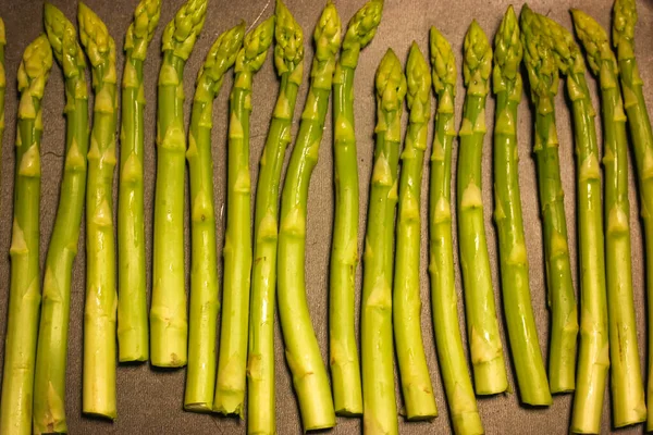 Un mazzo di asparagi freschi maturi su fondo nero, cibo biologico sano — Foto Stock