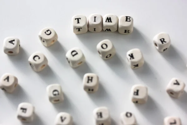 Tijd - de woorden geschreven op houten blokken, witte tafel, zwart-wit letters — Stockfoto
