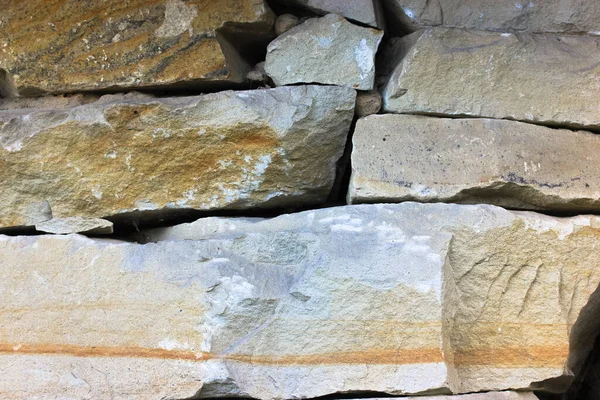 Πέτρινος τοίχος σε γκρι και καφέ απόχρωση φυσικού χρώματος, φόντο και υφή πέτρινου τοίχου από μεγάλους λίθινους ογκόλιθους, μοντέρνα κατασκευή και αρχιτεκτονική — Φωτογραφία Αρχείου