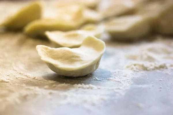 Veel Ongekookte Knoedels Het Oppervlak Van Een Houten Witte Keukentafel — Stockfoto