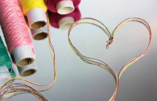 一个多彩的线的心脏 喜欢缝纫和针线活 镜面线圈上的螺纹 — 图库照片
