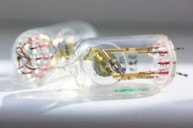 Beyaz arka planda izole edilmiş iki eski elektronik vakumlu radyo tüpü. Sovyetler Birliği tarafından üretilen şeffaf lambalar. Vintage cam transistörler yakın plan..