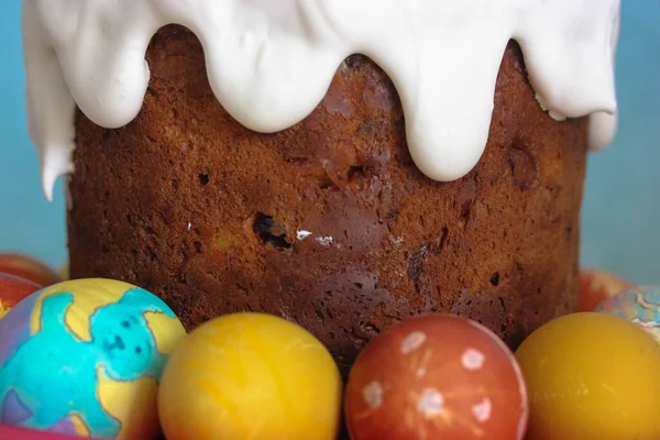 Traditional easter festive cake with frosting close-up. Multicolored Easter eggs in the foreground. Easter egg with the image of a bunny. High quality photo
