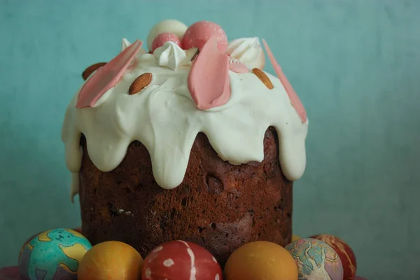 Traditional easter festive cake with frosting close-up. Multicolored Easter eggs in the foreground. High quality photo.