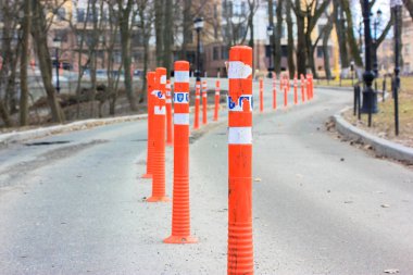 Esnek güvenlik PVC çizgileri, turuncu plastik yol direkleri, seçici odaklanma. Trafik konileri. Şehirdeki iki yönlü arabalar için asfalt yol. Apartmana giden yol..