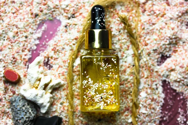ガラス瓶の中の黄金の油血清エッセンスを平らに 自然の化粧品 美容スキンケア 夏の日に顔 体を保護するために日焼け止め油 海のテーマ ピンクの砂 ハート型の石 — ストック写真