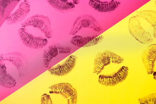 Abstract purple red lipstick kisses on yellow pink art background. Lots of prints of women\'s lips on paper. Beautiful lips stamps isolated. Valentines day, romantic love concept. Lipstick kisses.