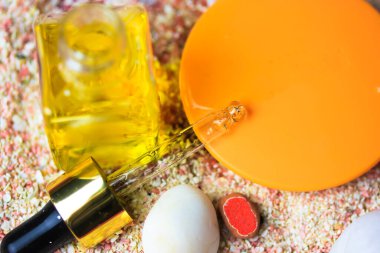 Damla şişesi ve gerekli yağ. Hyaluronik asit, kozmetik serumu ya da kabuklu bir şişedeki gerekli yağ, düz bir şekilde kum arka planı. Güneşten korunmak için güneş kremi. Doğal kozmetik, cilt bakımı. 