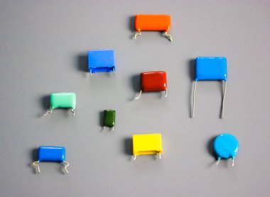 Gri arka planda çok renkli film kondansatörleri. Vintage elektronik parçalar