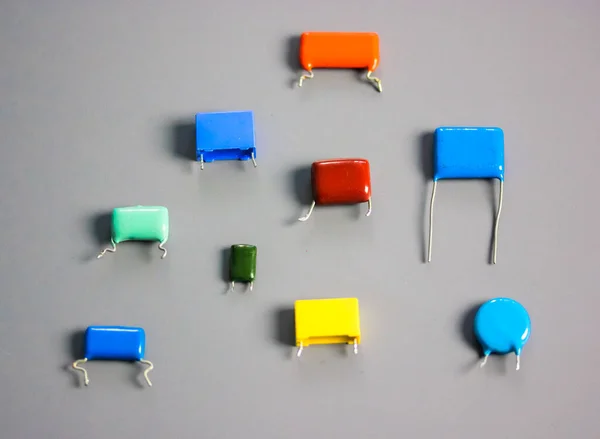 Condensadores de película multicolor sobre fondo gris. Piezas electrónicas vintage — Foto de Stock