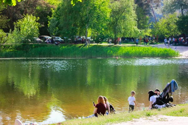 在温暖的春天或夏日 人们在湖岸或河边休息 绿树成荫 草木茂盛 构成平静的水 周末度假时公园或森林里的自然娱乐活动 — 图库照片