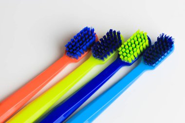 Plastik renkli diş fırçaları seti - yeşil, mavi, kırmızı - beyaz arka planda izole edilmiş. Parlak renkli, yumuşak diş fırçaları ve çok renkli kalkanları var. Diş sağlığı konsepti. 