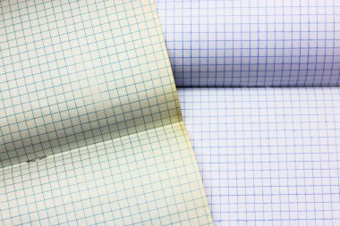 Boş defter sayfaları arka planda. Damalı çarşaflı bir defter açılmış. Okul defterindeki kafesin içinde boş bir sayfa. Çalışma ve iş malzemeleri. Yüksek kalite fotoğraf
