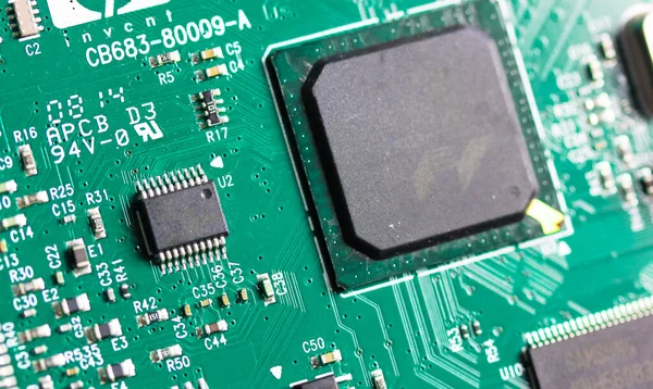 Düz yeşil bir elektronik devre kartı. PCB panosunun üst görüntüsü, yakın plan. Çeşitli elektronik parçaları elektriksel ve mekanik olarak bağlamak için amatör radyo tasarımları. Teknoloji geçmişi