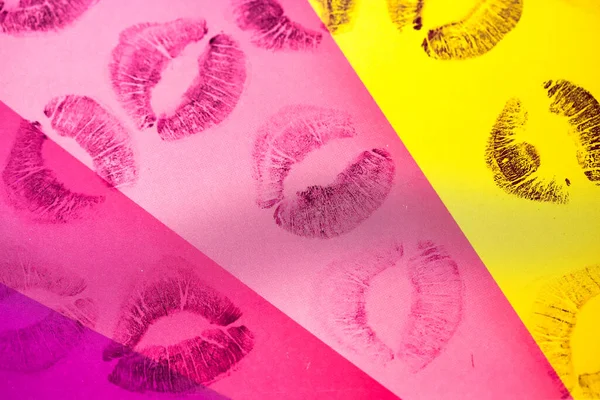 Abstract purple pink lipstick kisses on yellow pink art background. Lips stamps.