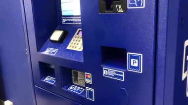 Ödeme istasyonunda park ücreti ödeyen bir sürücü, ATM 'den ödenmiş bir park yeri. PayPass ile terminali ve akıllı telefonu kullanan biri. Modern bir park sayacının deliğine ceza kesen bir el. Otomatik park süresi