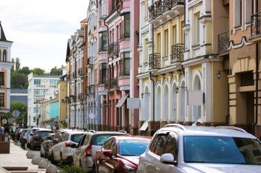 Çok renkli eski modern evlerin cephesi. Bakış açısıyla Avrupa 'nın rahat caddesi. Yaz günü yol kenarında park etmiş arabaların olduğu bir şehir caddesi. Modern renkli mimari. Ön cephe oluşturuluyor