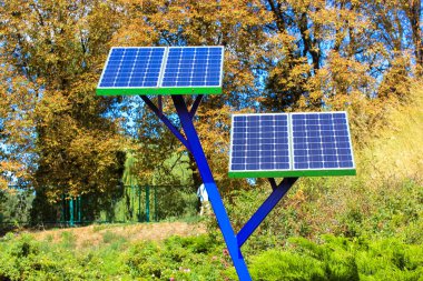 Şehir parkına cep telefonlarını şarj etmek için kurulmuş küçük güneş enerjisi panelleri. Güneş pili, bahçıvanlık, tarım ve bahçıvanlıkta jeneratör kullanmak. Elektrik üretimi. Ortamı kaydet.
