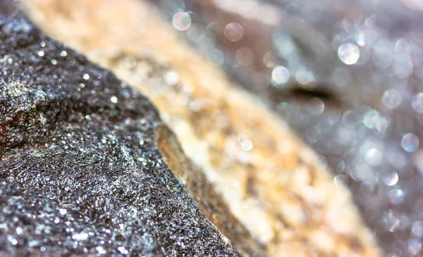 石のテクスチャを近いうちに花崗岩 侵入岩の背景 ゴールデンまたはベージュのストライプと大規模な未処理の濃い灰色の輝く石の表面 天然素材 大理石岩のマクロ写真の背景 — ストック写真