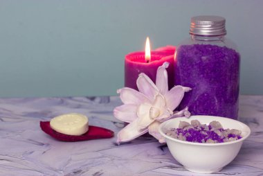 Bir kavanoz mor lavantalı deniz tuzu, sabun çubuğu, yanan leylak mumu ve güzel çiçekli kompozisyon. Spa prosedürü, vücut, yüz bakımı. Kozmetik ürünler. Güzellik salonunda banyo tedavileri..