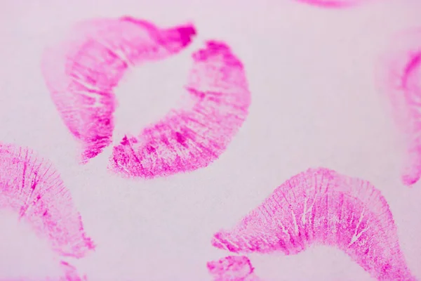 Beautiful shape pink female lip prints on white paper background top view. Kisses flat lay. Lipstick print, marks. Femininity, flirt, love concept. World Kissing Day. Valentine's Day. Lovely backdrop.