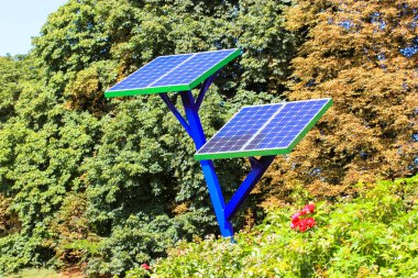 Şehir parkına cep telefonlarını şarj etmek için kurulmuş küçük güneş enerjisi panelleri. Güneş pili, bahçıvanlık, tarım ve bahçıvanlıkta jeneratör kullanmak. Elektrik üretimi. Ortamı kaydet.