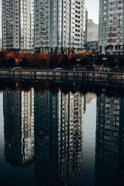 Kyiv, Ukrayna 4 Ekim 2025 Modern rıhtım binaları alacakaranlıkta sakin suya yansıdı. Evlerin simetrik yansımaları, suyun yüzeyine çarpıcı bir görsel efekt modern mimari