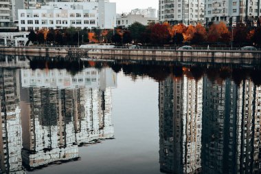 Kyiv, Ukrayna 4 Ekim 2025 Modern rıhtım binaları alacakaranlıkta sakin suya yansıdı. Evlerin simetrik yansımaları, suyun yüzeyine çarpıcı bir görsel efekt modern mimari