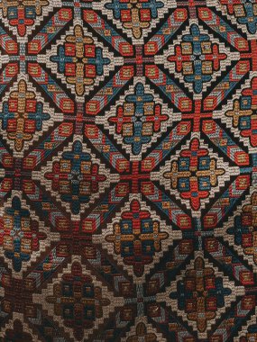 Geometrik şekilleri ve canlı renkleri olan karmaşık tekstil deseni. Bu detaylı tekstil, arka plan ve dokular için mükemmel, tekrar eden elmas ve çapraz motiflere sahip karmaşık bir tasarım sergiliyor.. 
