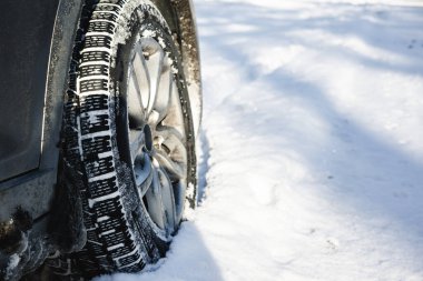 'Çevre Gerçekçiliği' trendini somutlaştıran, parlak, güneşli bir günde, yüksek traksiyonlu bir kış lastiği derin, taze kara batar. Karların ham dokusuna odaklan ve otantik mevsimsel içerik için kauçuk.