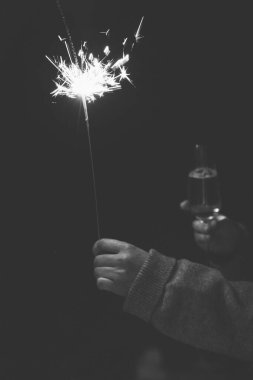 Dramatik bir sade çekim kutlama anını yakalar. Aydınlık maytap ve derin gölgeler arasındaki katı kontrast ile Karanlık trend. Huysuz, otantik yaşam tarzı estetiği. Şenlikli parti sahnesi.