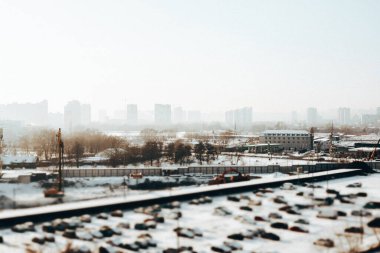 KYIV, Ukrayna. 15 Ocak 2026 Kış Şehir İnşaat Alanı. Ağır makineleri ve park edilmiş arabaları var. Yukarıdan çekilmiş. Karlı şehir manzarası, altyapı gelişimi.